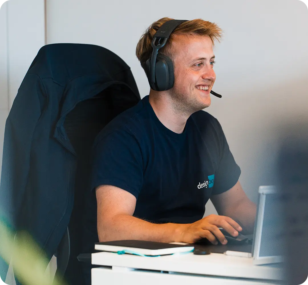 A designbox team member smiling at their desk in the studio